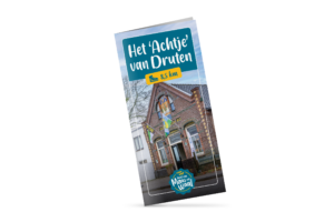 Tilted blue sign reading 'Het Achtje van Druten' with a yellow 8,5 km badge above a brick building façade, indicating a local route distance.